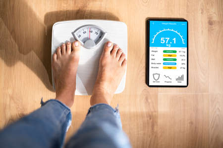 Smart Weight Scale With Wireless Tablet App. Woman Standing And Weighingの写真素材