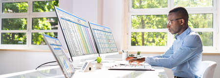 Businessman Working With Spreadsheets On Desktop Computerの写真素材