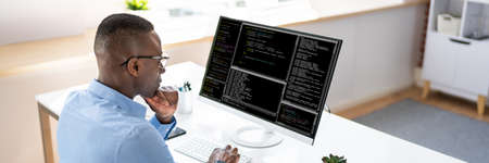 African American Coder Using Computer At Desk. Web Developer