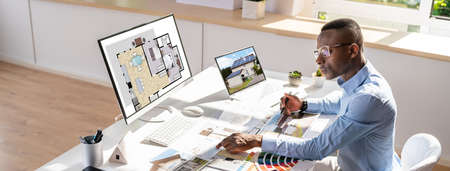 Side View Of Real Estate Designer Working On Computer In Office