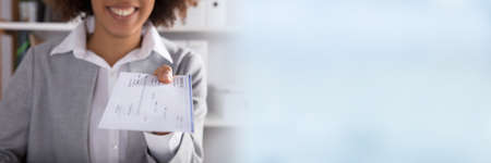 Businessperson Hand Giving Cheque In Office At White Deskの写真素材
