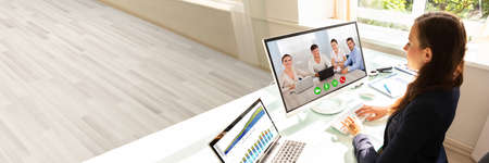 Side View Of A Young Businesswoman Videoconferencing With Her Colleagues On Computer