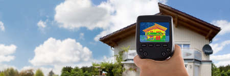 Close-up Of Person Detecting Heat Loss Outside House Using Infrared Thermal Cameraの写真素材