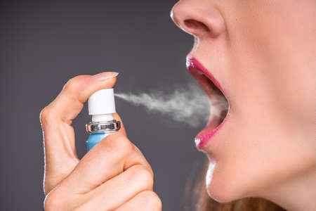 Close-up Of A Woman Applying Fresh Breath Spray