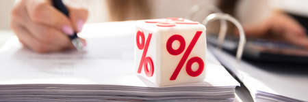 White Cubic Block With Red Percentage Symbol Over Documentの写真素材