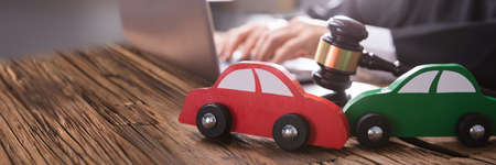 Close-up Of Two Green And Red Wooden Cars On Desk In Courtroom