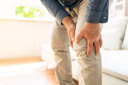 Man Suffering From Knee Pain While Trying To Stand upの写真素材
