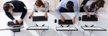 Elevated View Of Call Center Operator Team With Headset Working In Office