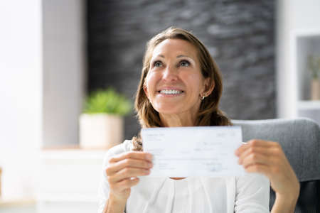 Close-up Of A Smiling Businesswoman Showing Company Cheque
