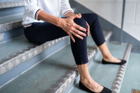 Mature Woman Sitting On Staircase After Slip And Fall Accidentの写真素材