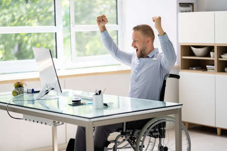 Disable Young Worker Using Computer. Physical Therapy In Wheelchairの写真素材