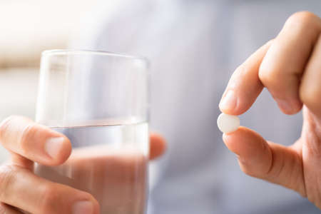 Sick Man Taking Medicine Drug. Antibiotic In Handの写真素材