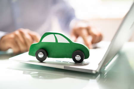 Close-up Of A Small Blue Car On Laptop Keypadの写真素材