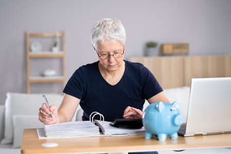Senior Woman Calculating Bills In Her Roomの写真素材