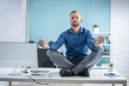 Employee Doing Mental Health Yoga Meditation In Officeの写真素材