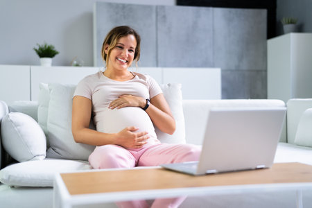 Pregnant Woman Using Online Video Call With Doctor On Laptopの写真素材