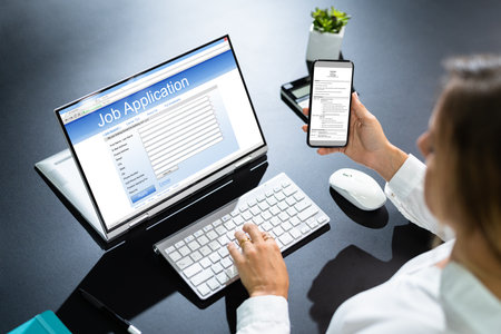 Person Hands Filling Online Job Application On Mobile Phone At Desk