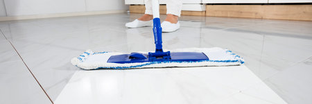 Cleaning White Floor Tiles With Mop In Kitchen