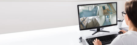 Person Watching CCTV Footage On Computer Screenの写真素材