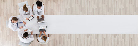 Medical Doctor Group Meeting At Desk With Laptop Computerの写真素材