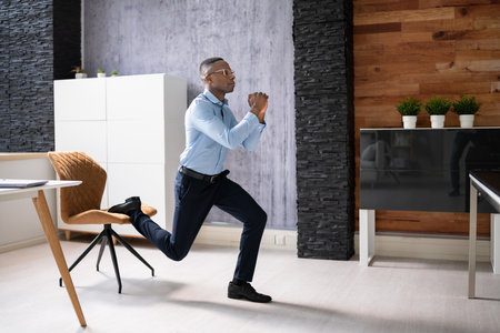 African Employee Doing Bulgarian Split Squat Exercise In Officeの写真素材