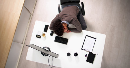 Tired African Businessman Sleeping In Office At Desk