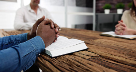 Group Of People Reading Bible On Wooden Deskの写真素材