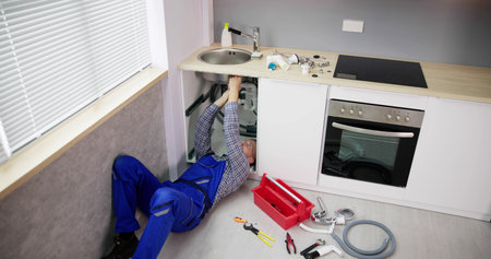 Plumber Cleaning Kitchen Drain And Pipe Using Toolsの写真素材