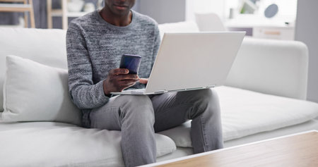 Sitting Home Using Computer Technology In Living roomの写真素材