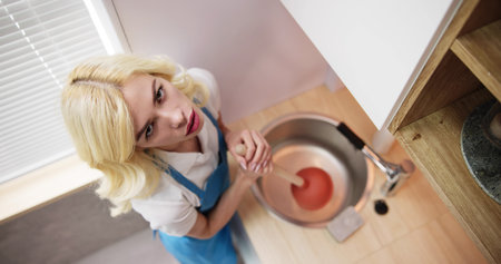 Cleaning Blocked Sink And Drain In Kitchen Using Plungerの写真素材