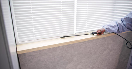 Male Pest Control Worker With Spraying Pesticide In Kitchenの写真素材