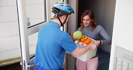 Delivery Man Giving Grocery Plastic Box To Womanの写真素材