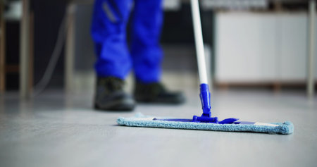 Portrait Of Happy Male Janitor Cleaning Floor At Officeの写真素材