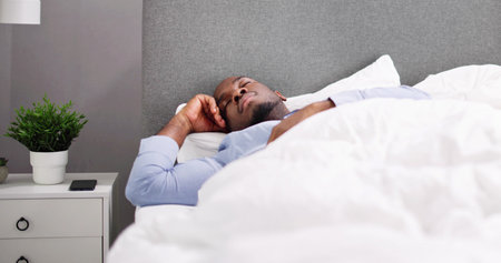 Young Happy Smiling African Man Waking Up At Bedroom
