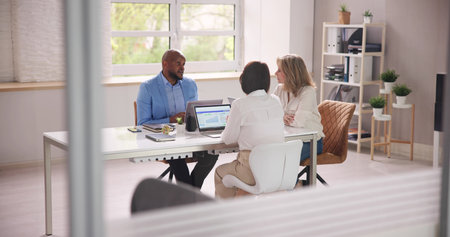 Group Of Businesspeople Sitting In Office During Business Meeting