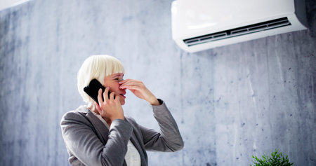 Broken Air Conditioner Repair. Woman Calling Repair Serviceの写真素材