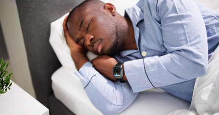 Man Sleeping With Smart Watch In His Hand Showing Heartbeat Rateの写真素材