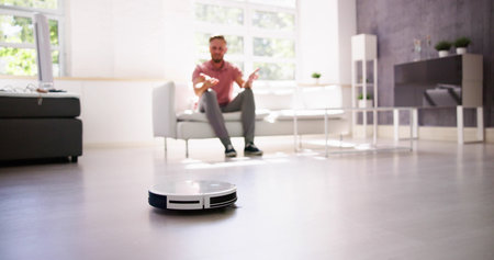Home Robot Cleaner Doing Housework Near Sofaの写真素材