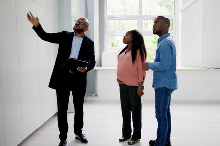 African Couple Viewing Real Estate House With Realtorの写真素材