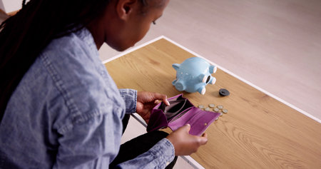 Upset Mid Adult Woman Holding Empty Wallet While Sitting On Sofa At Home