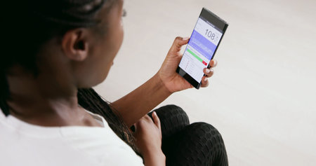 Woman Testing Glucose Level With Continuous Glucose Monitor On Mobile Phone
