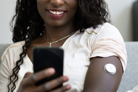 African Woman Using Continuous Glucose Remote Monitor Diabetes Sensor