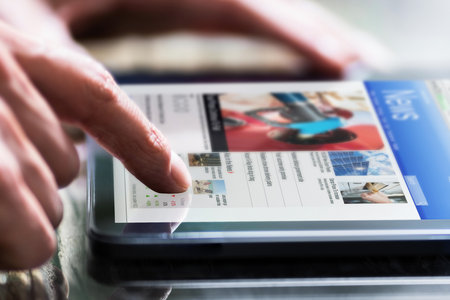 Reading Newspaper Article Online On Digital Tabletの写真素材