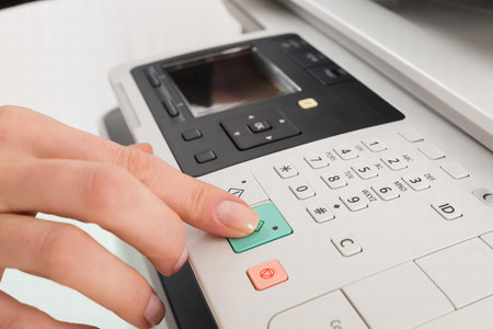 Close-up Of Businesswoman Hand Pressing Printer's Button