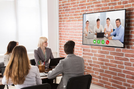 Group Of Businesspeople Having Video Conference In Boardroomの写真素材