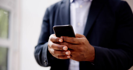 African Man Holding Smartphone Or Mobile Phoneの写真素材