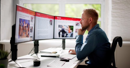 Man Reading News Website On Computer Screen