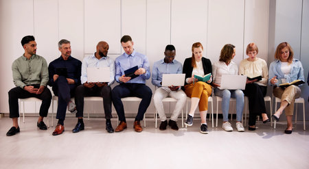 Row Of Diverse People Waiting For Job Interview In Office