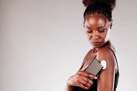 Happy African American nurse using a digital smartphone app to monitor and analyze a diabetic...