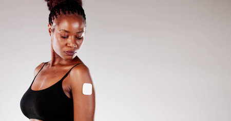 Close-up of African American Woman Applying Contraceptive Nicotine Patch for Smoking Cessation...